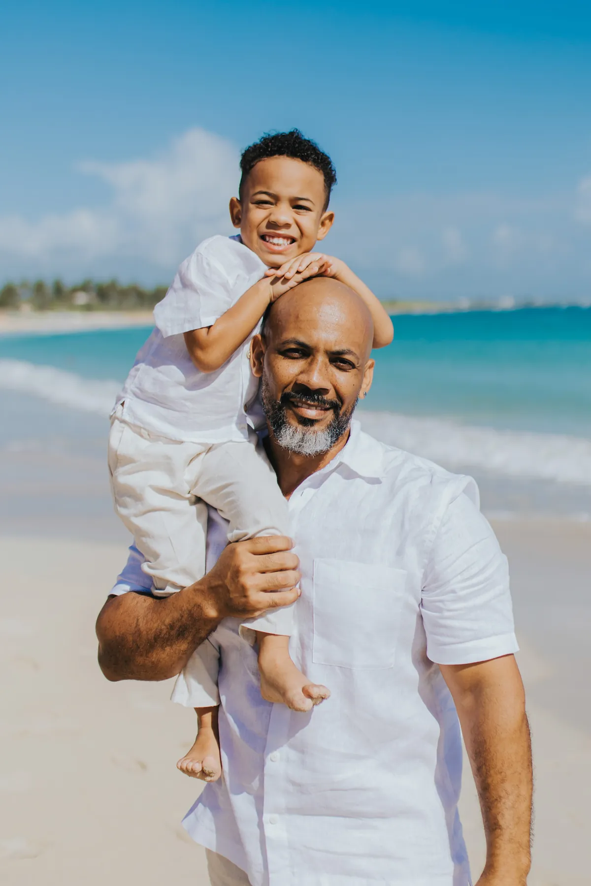 Father carrying his son on his shoulders, both smiling