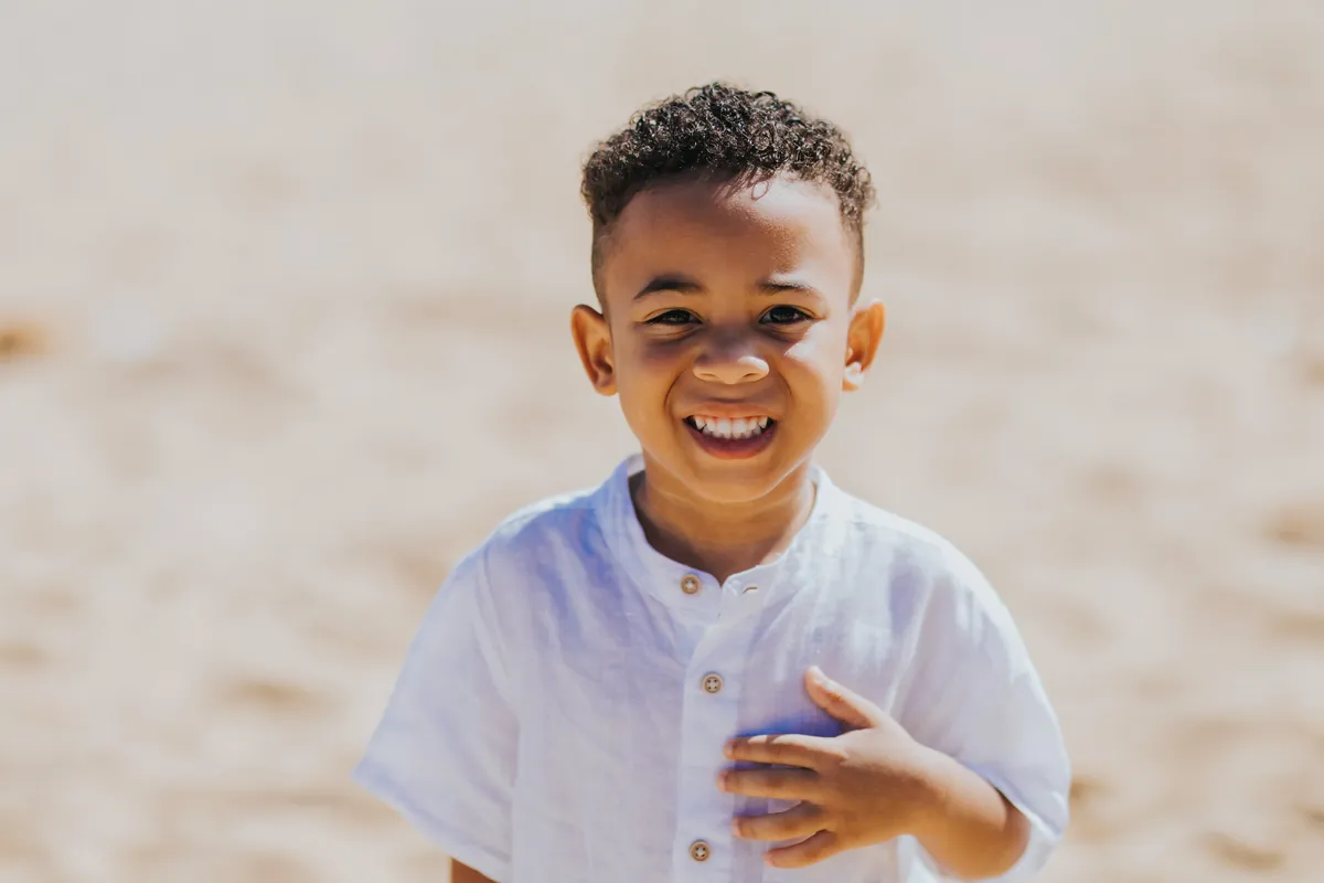 Close-up of a little boy laughing on the beach