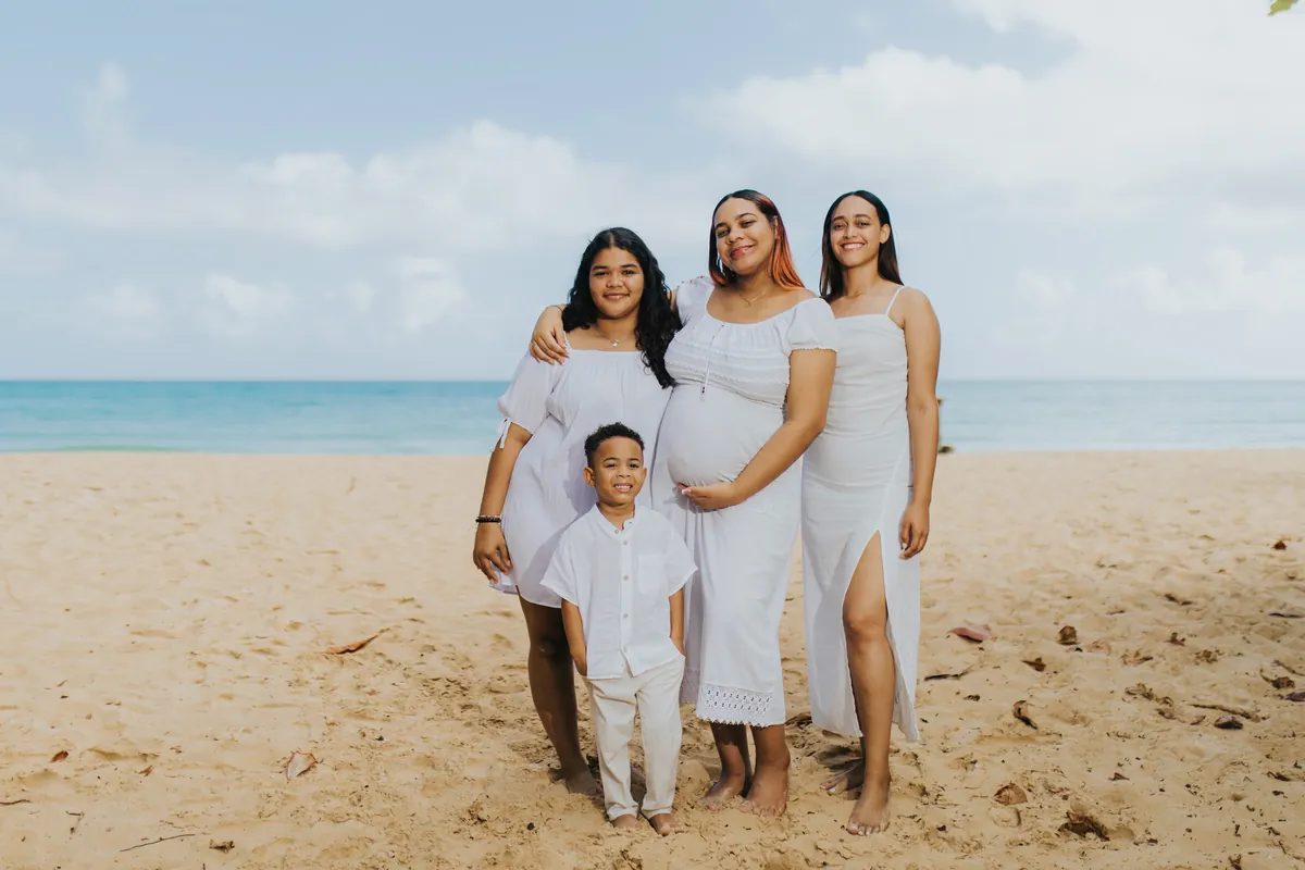 Mom-to-be with her daughters and son on the sand