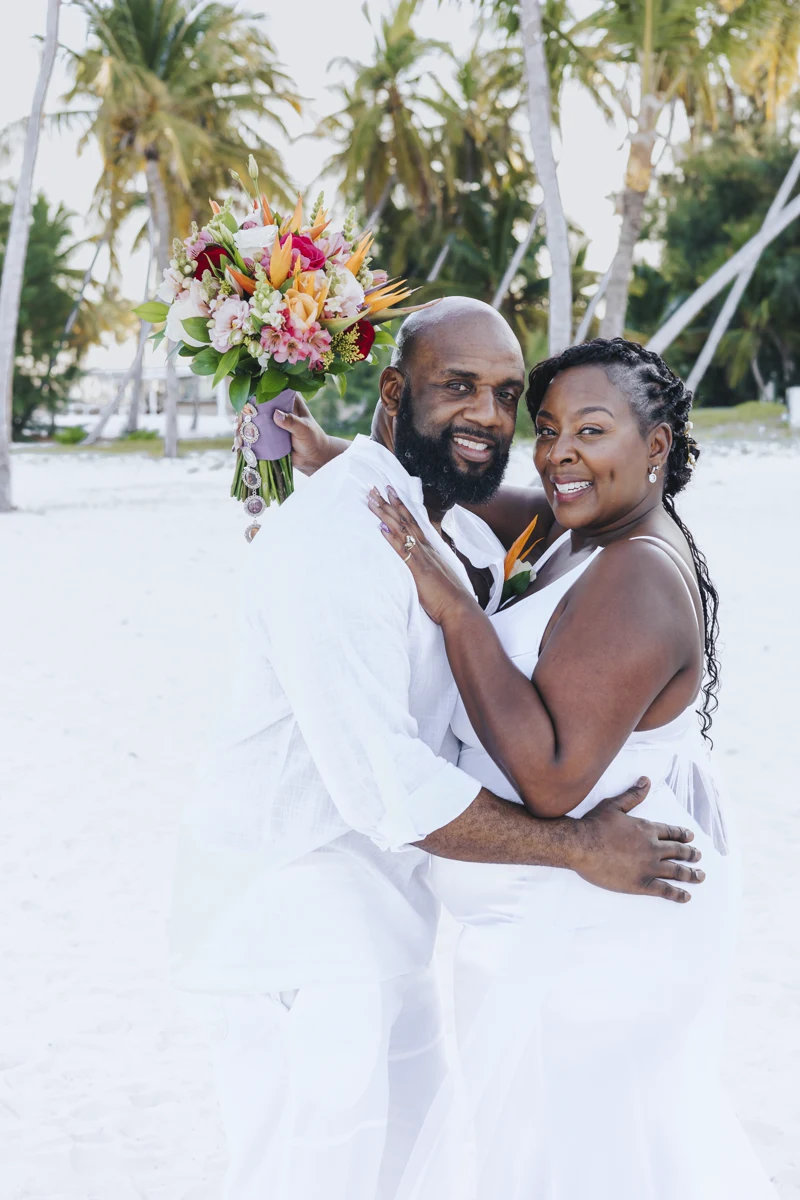Pareja recién casada abrazándose en la playa