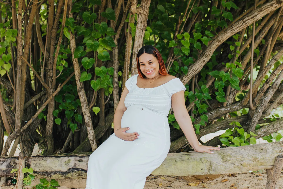 Expecting mom smiling on a log in the shade