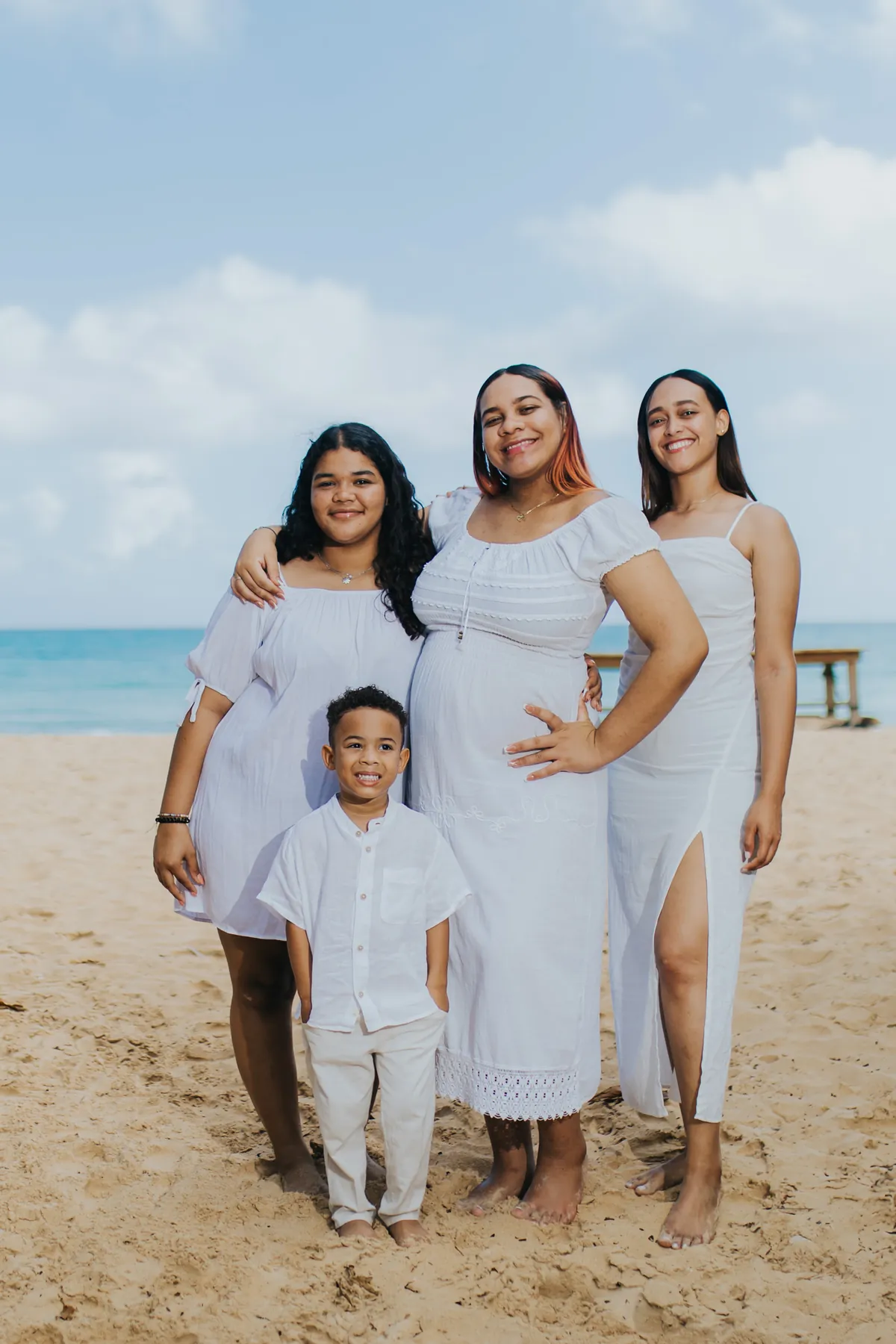 Pregnant mom with her daughters and son on the beach