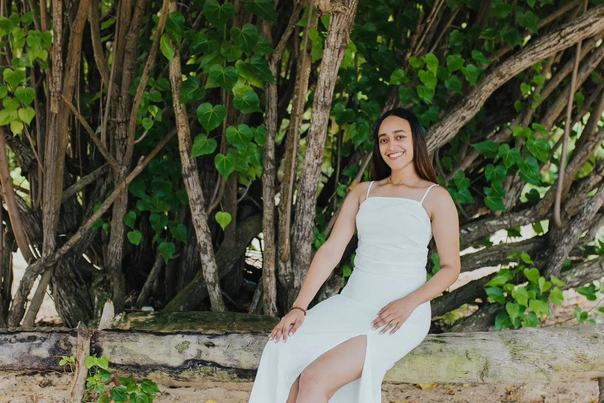 Portrait in a white dress framed by green leaves