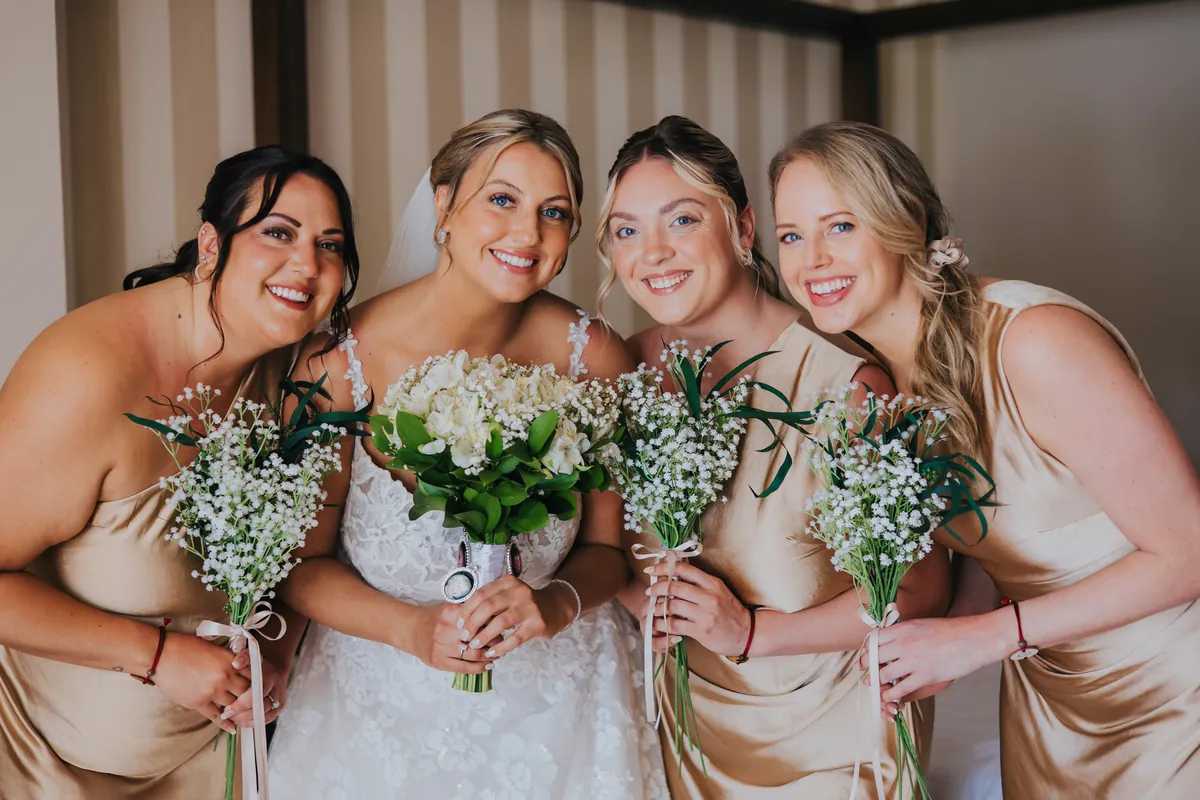 Bride with her bridesmaids holding baby's breath bouquets