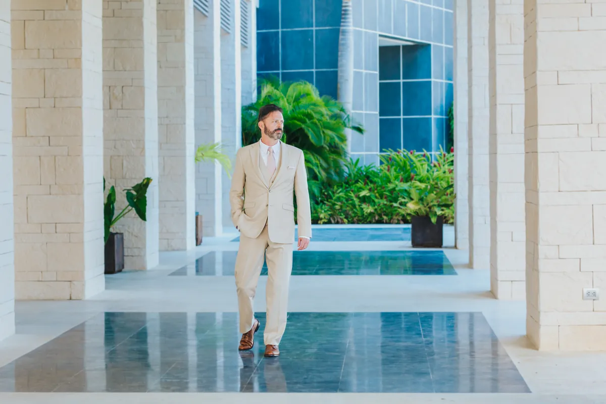 Groom walking through a resort colonnade