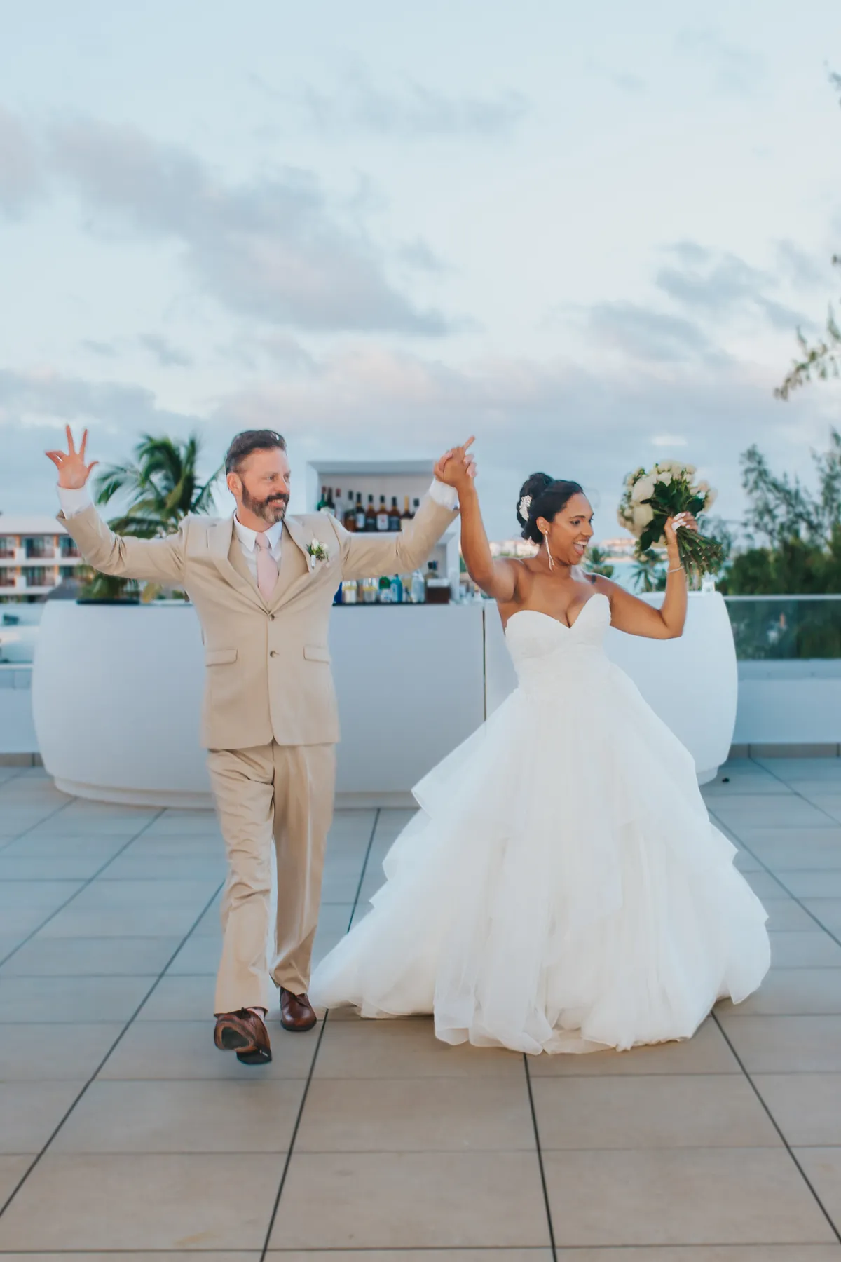 Recién casados entrando bailando a su recepción en la terraza